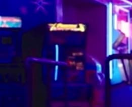 Neon-lit arcade scene with blurry purple and blue color palette