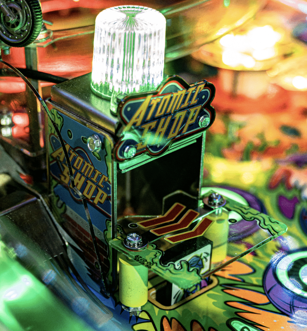 Atomic Shop pinball machine with illuminated white light and colorful design