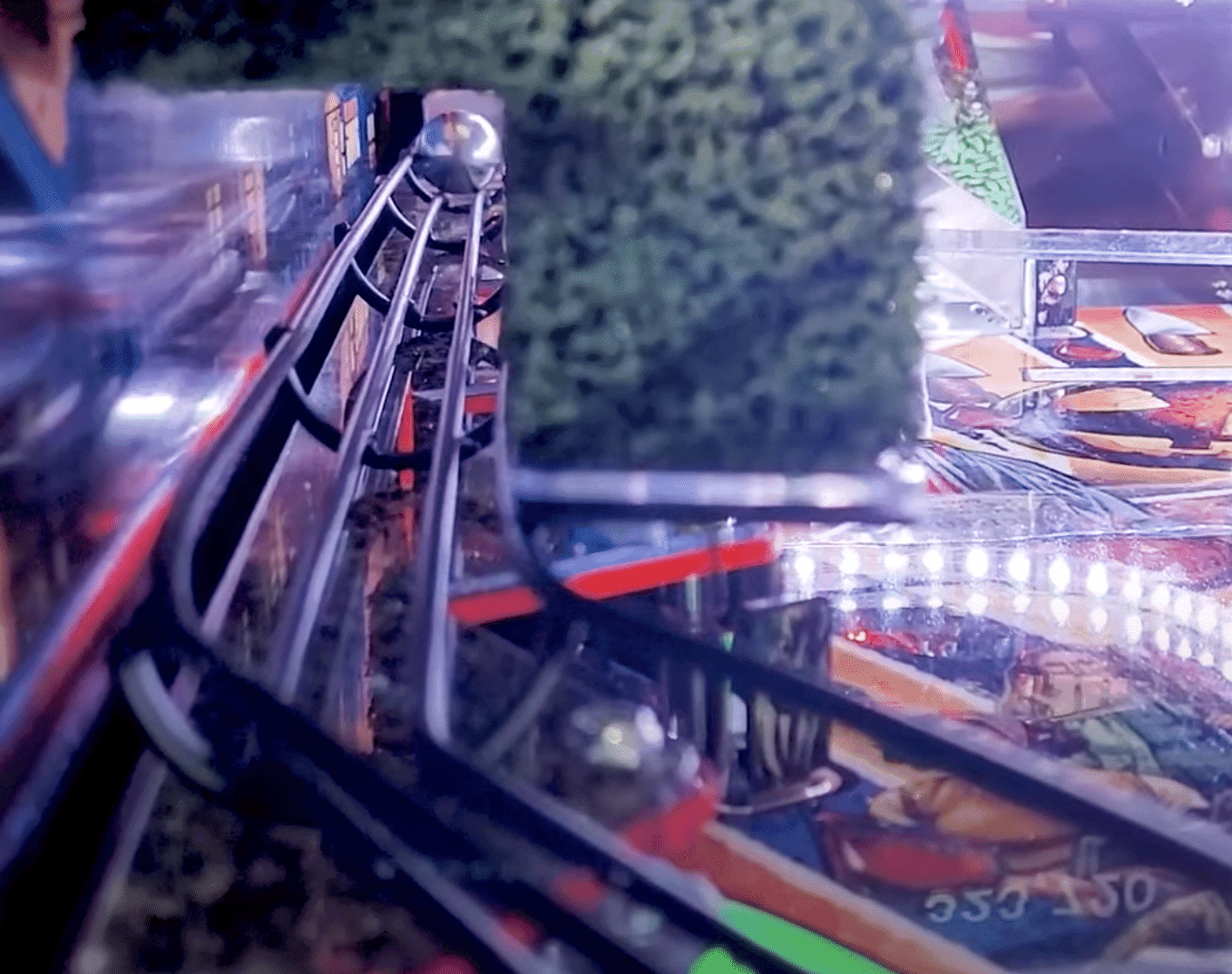Pinball machine close-up with silver ball on metal ramp and blurred background