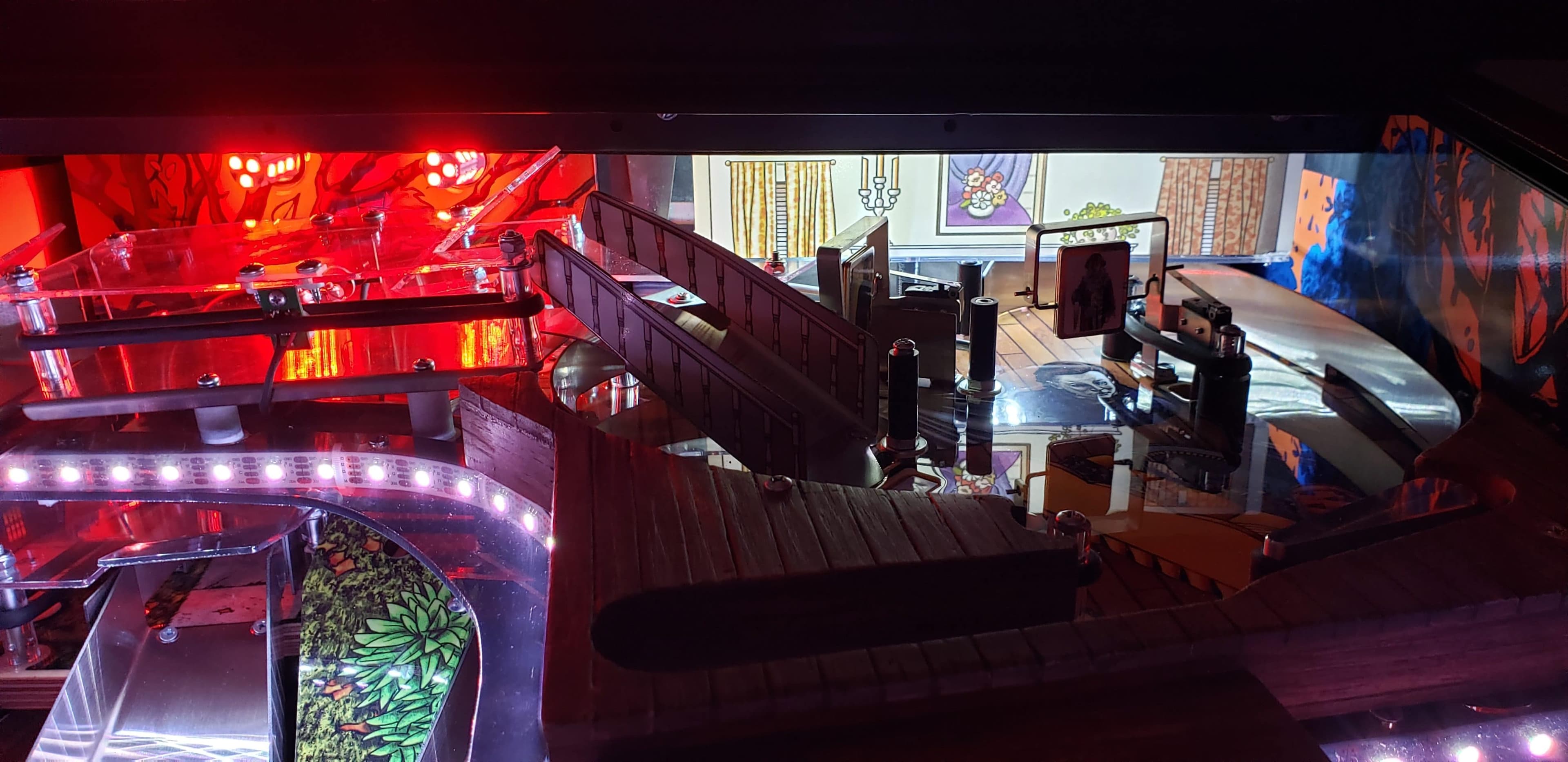 Pinball machine interior with red lights and intricate mechanical components