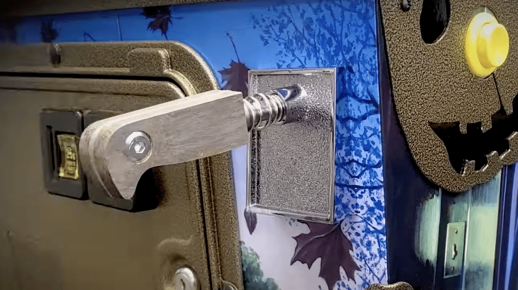 Metal lever attached to textured surface with autumn leaves background