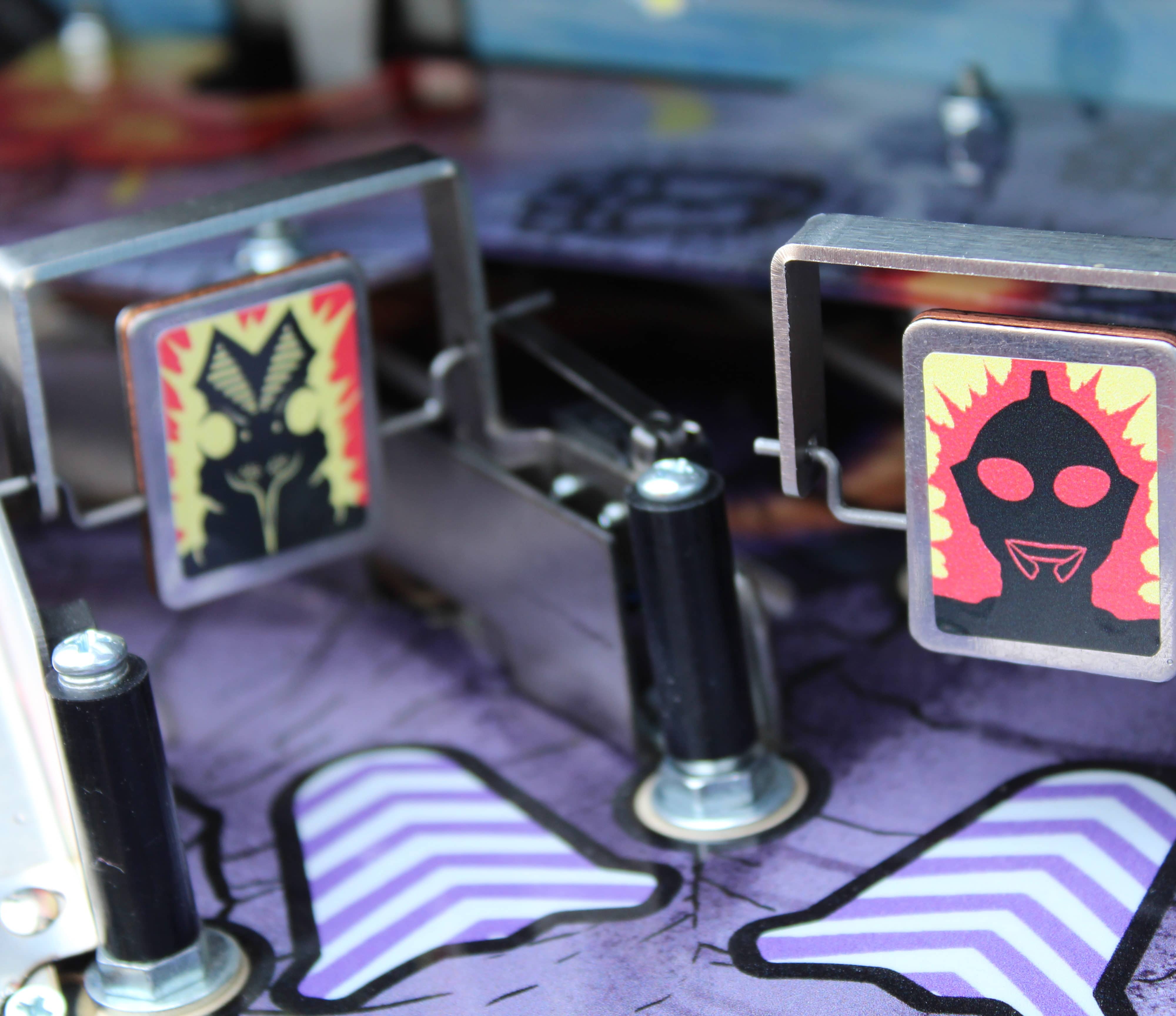 Ultraman and monster icons on mechanical game board with metal parts