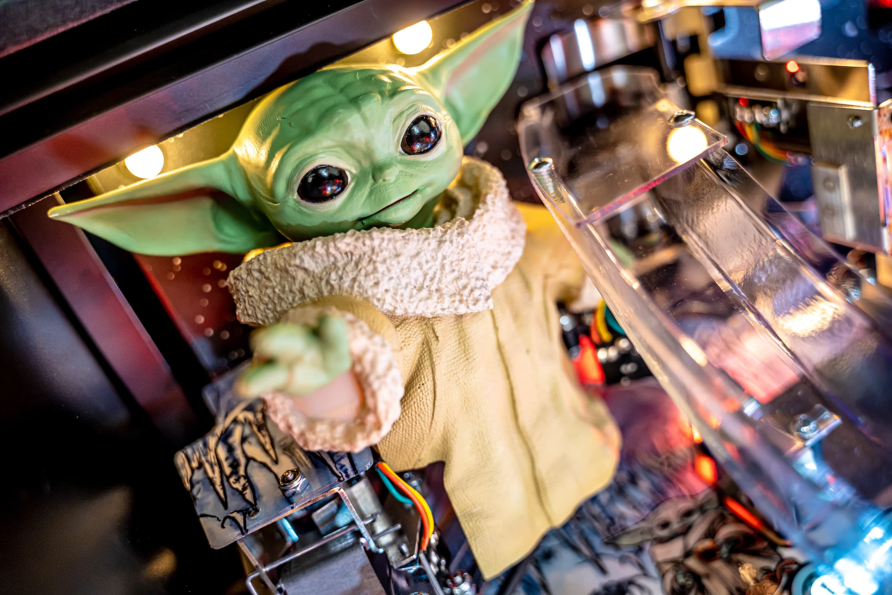 Grogu (Baby Yoda) figurine sitting among electronic components and lights