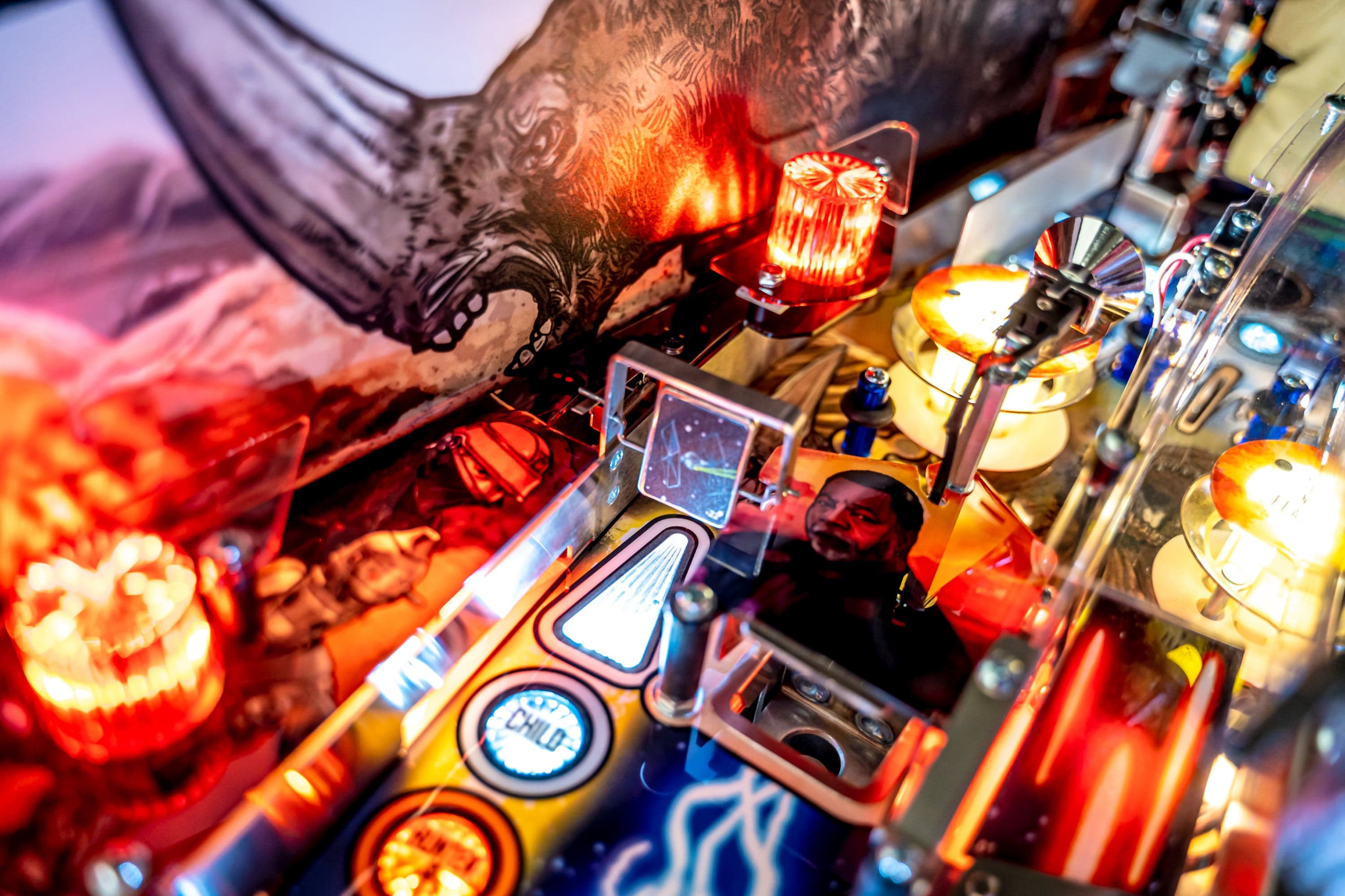 Close-up of a colorful pinball machine with glowing lights and intricate details