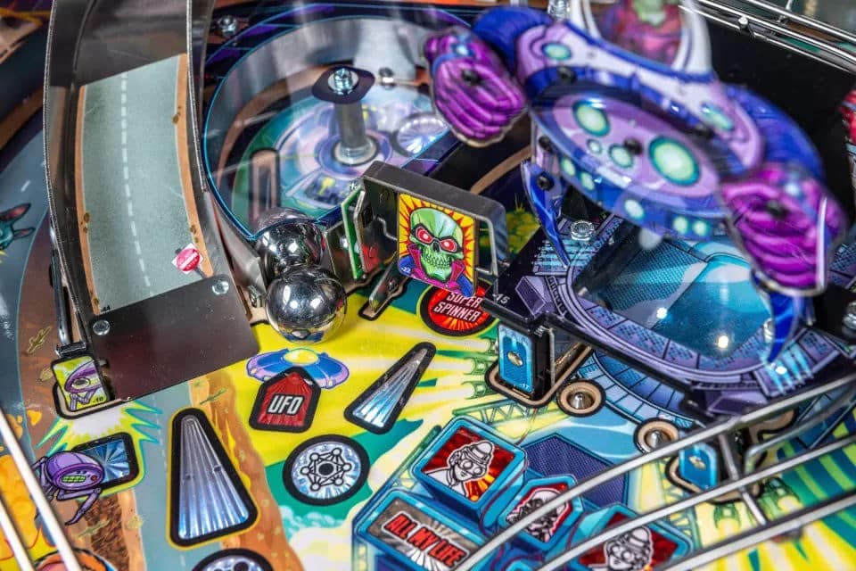 Colorful pinball machine with metallic balls, vibrant graphics, and sci-fi theme