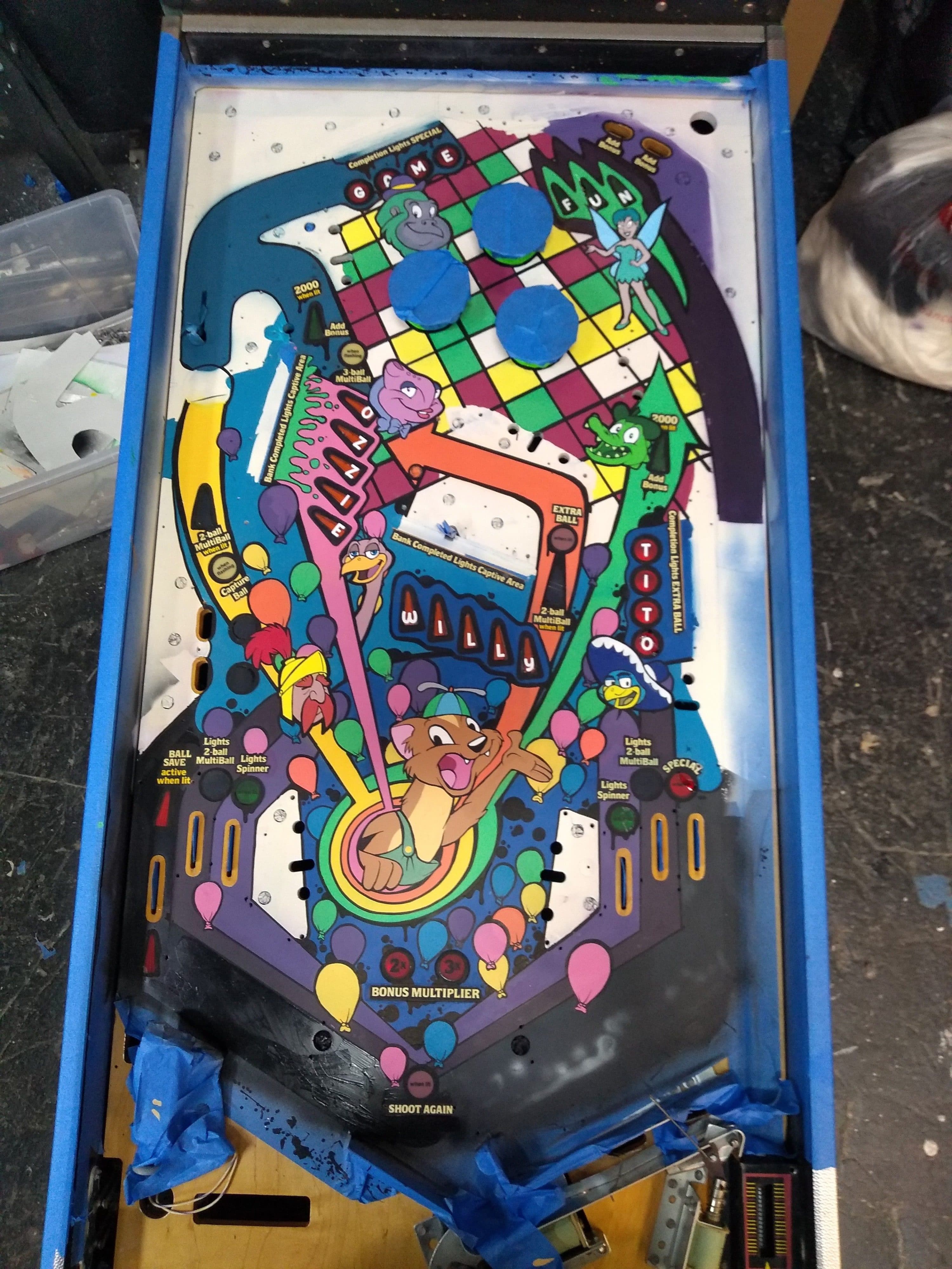 Colorful cartoon pinball machine playfield with cartoon characters and balloons