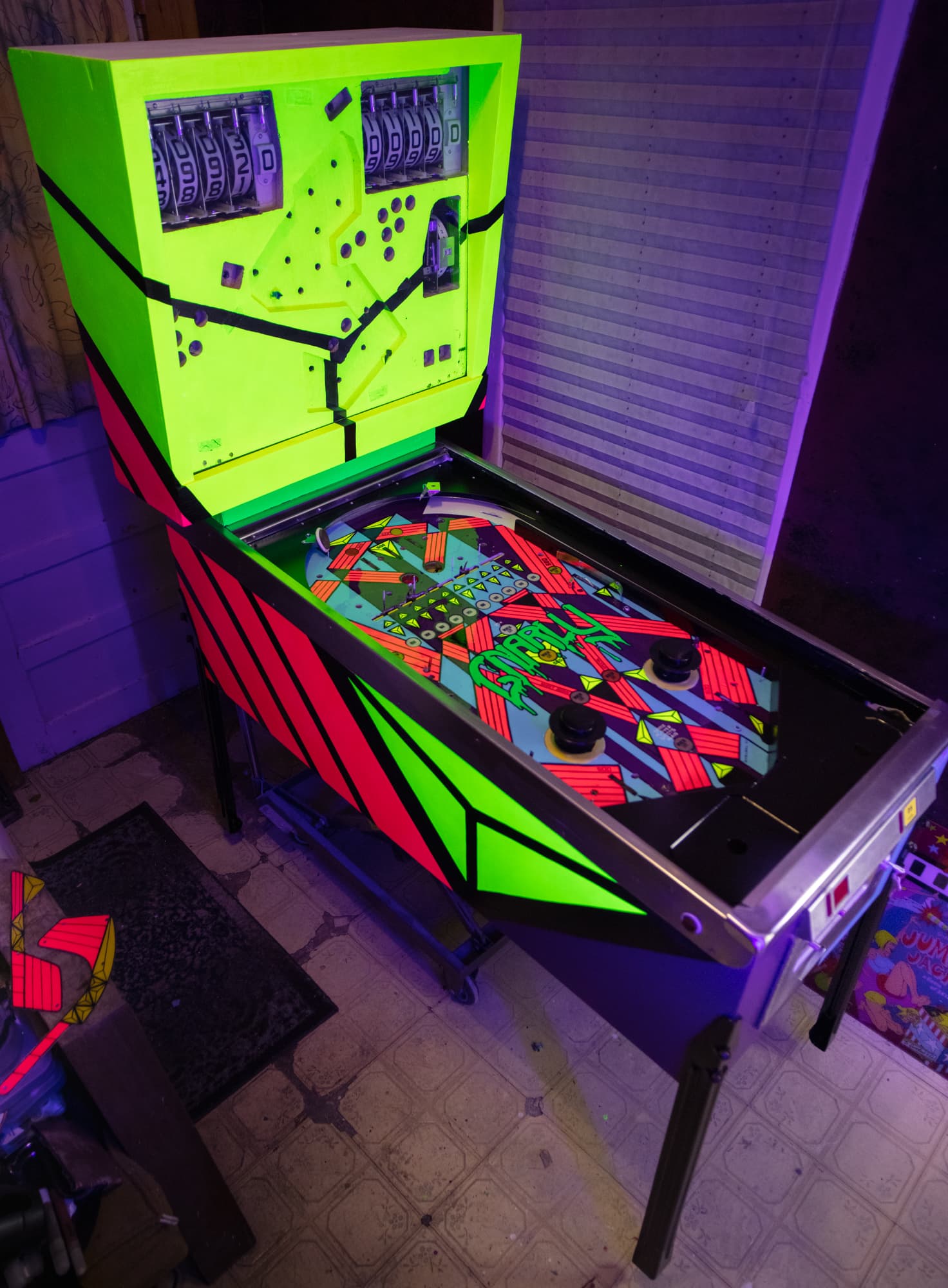Neon green and red pinball machine with vibrant playfield under purple lighting
