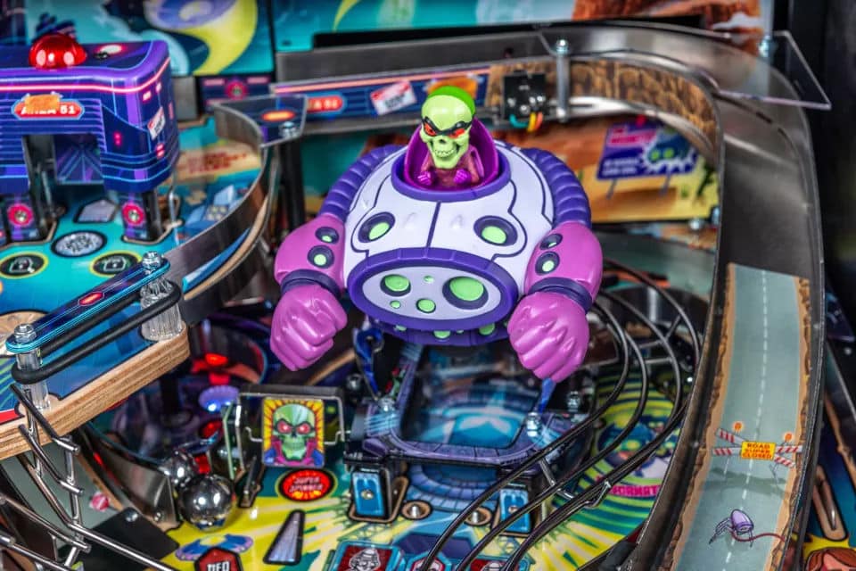 Colorful alien robot on a vibrant pinball machine playfield