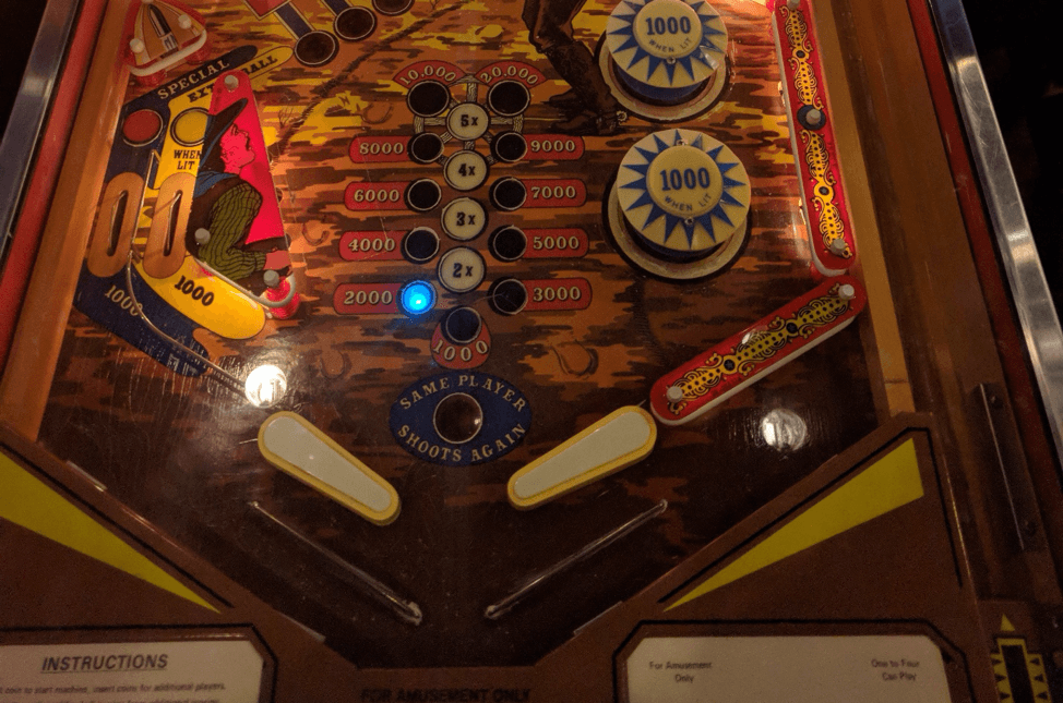 Vintage pinball machine playfield with scoring lights and bumpers