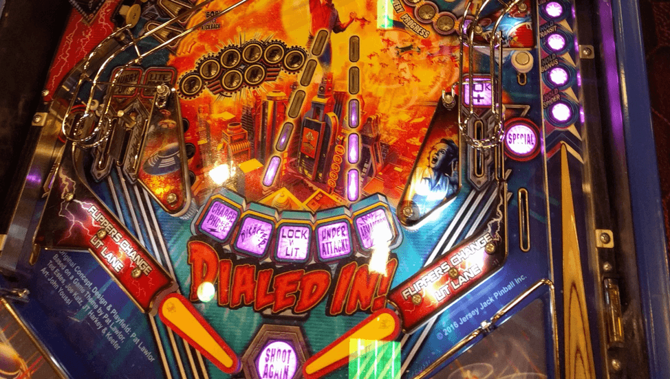 Colorful pinball machine playfield with vibrant lights and "Dialed In!" text