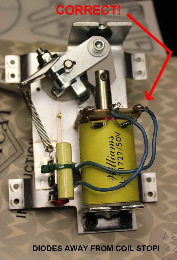 Electrical components and yellow coil on mechanical mounting with blue wires