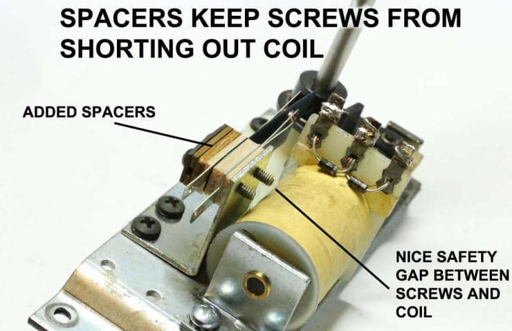 Mechanical device showing spacers preventing screws from shorting out coil